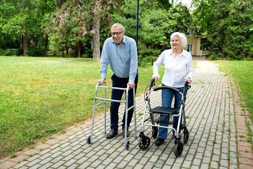 Family members helping a senior use a rollator outdoors