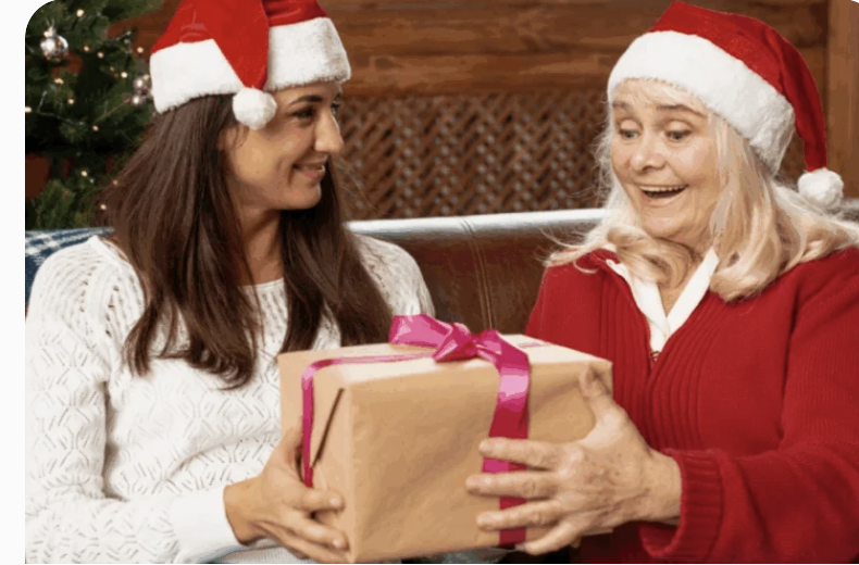 Woman giving a Christmas present to a senior woman