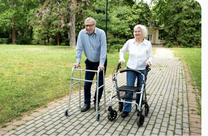 Senior couple walking outdoors with walkers