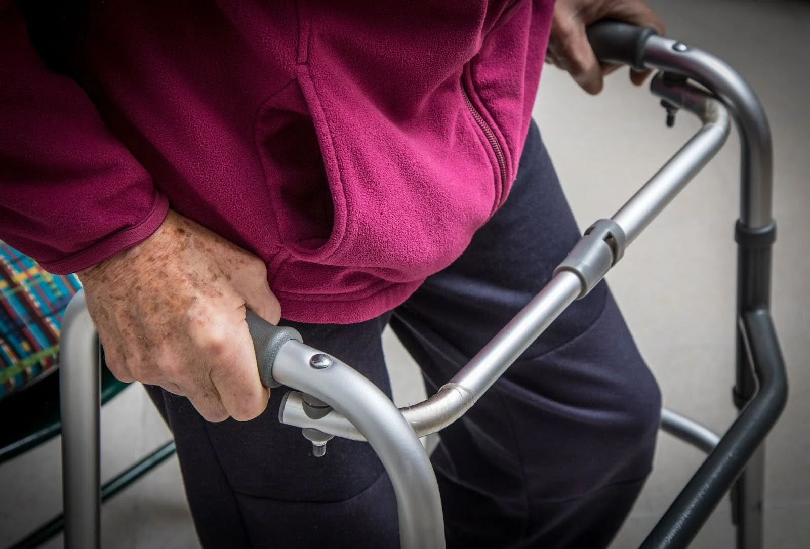 Senior using a 3-wheel walker indoors