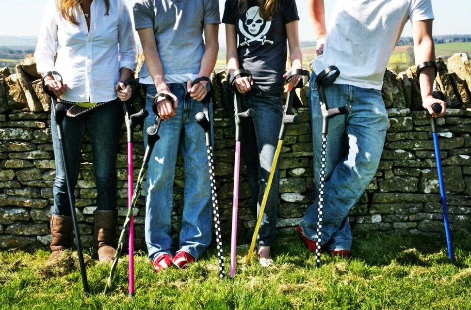 Group of people holding canes and walkers outdoors